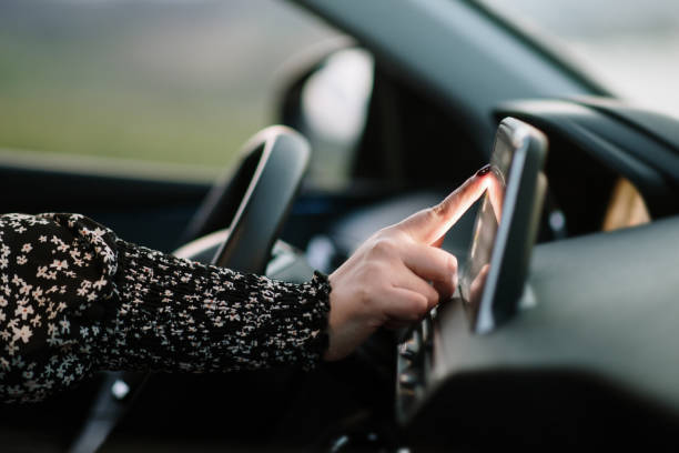 Woman touching the touch screen of a car stock photo