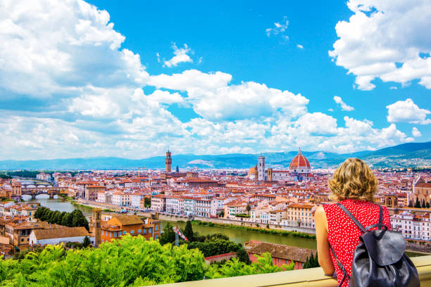 Woman tourist in red admires Florence Firenze (Duomo, Arno River, towers, cathedrals, tiled roofs of houses) from Piazzale Michelangelo, cityscape panorama top view, Florence, Tuscany, Italy Duomo Santa Maria Del Fiore, Bargello, Ponte Vecchio, Palazzo Vecchio in Florence architecture and landmark, skyline. florence italy stock pictures, royalty-free photos & images