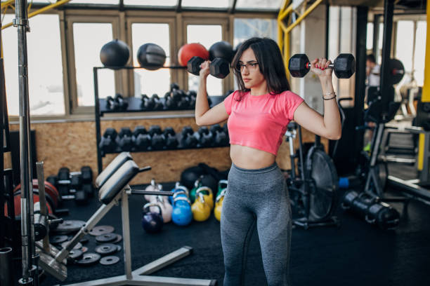 Woman training with dumbbells stock photo