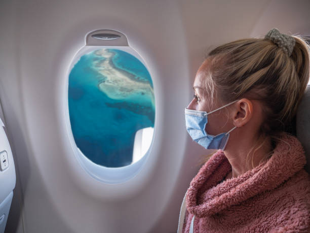 Woman traveling by plane during Coronavirus pandemic stock photo