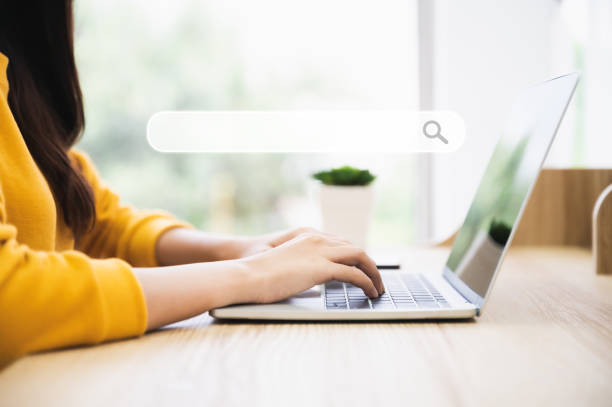 Woman using computer laptop on wood desk. She working at home stock photo
