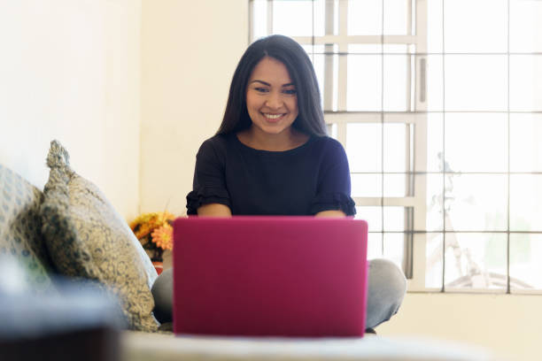 Woman using laptop and working at home stock photo