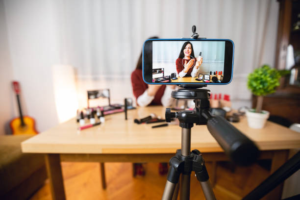 woman vlogging about makeup - smartphone filming imagens e fotografias de stock