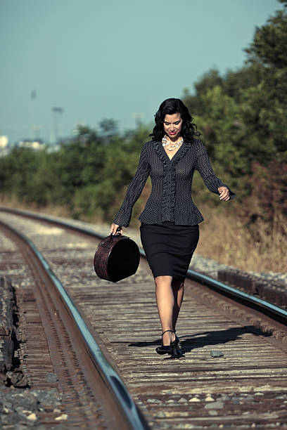 Woman Walking Down Train Tracks stock photo