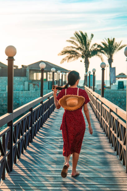 Woman walking in a seaside tropical resort on summer vacation Woman walking in a seaside tropical resort on summer vacation. Summer season travel unrecognizable destination abstract hot arab women stock pictures, royalty-free photos & images