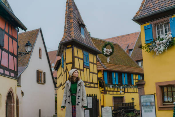Woman walking in Alsace town in France Young Caucasian woman  walking on the streets of Alsace town in France riquewihr stock pictures, royalty-free photos & images