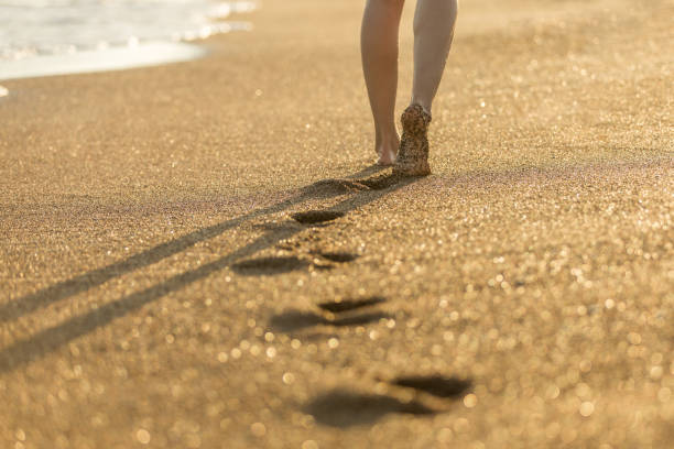 vrouw lopen op verzenden - voeten in het zand stockfoto's en -beelden