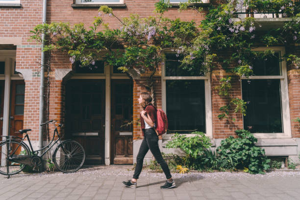 woman walking on the streets  of amsterdam - amsterdam street imagens e fotografias de stock