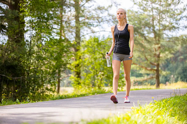 Woman walking outdoor in the forest as workout stock photo