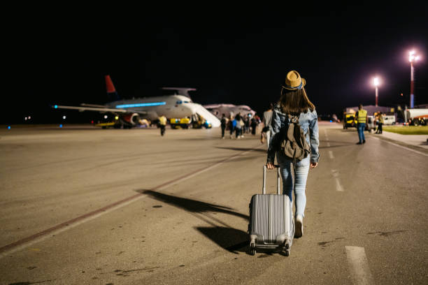 femme marchant vers l'avion - night lugage photos et images de collection