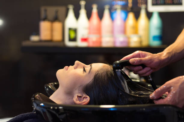 vrouw wassen haar in kapsalon - woman washing hair stockfoto's en -beelden