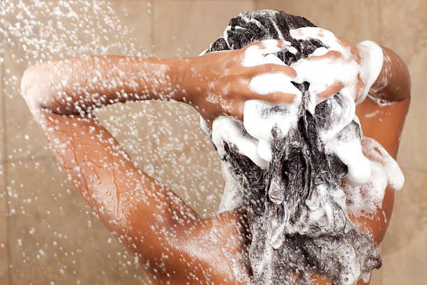 woman washing her hair with shampoo - woman washing hair stockfoto's en -beelden