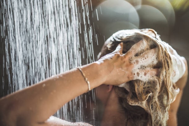 vrouw wassen haar met shampoo onder de douche. - woman washing hair stockfoto's en -beelden