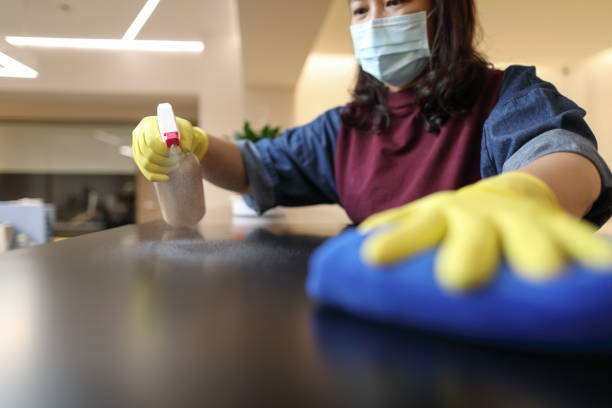 Woman wearing gloves cleaning desktop Woman wearing yellow gloves cleaning black countertop asian maid stock pictures, royalty-free photos & images