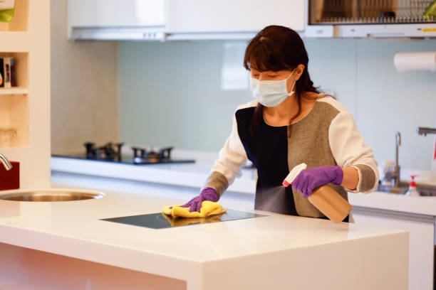 Woman wearing gloves cleaning desktop stock photo