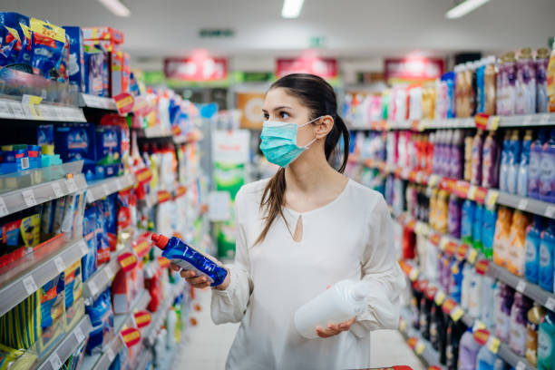 Woman wearing protective mask preparing for virus pandemic spread quarantine.Hygiene, cleaning and disinfection products.Preventive measures and protection.Supply shopping during the epidemic.  cleaning product stock pictures, royalty-free photos & images