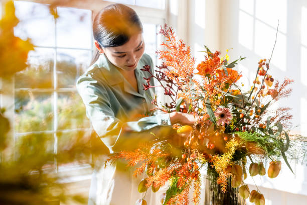A woman who arranges flowers at home stock photo