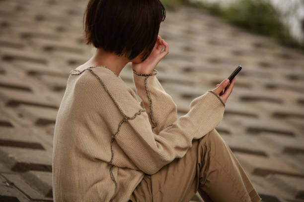 スマートフォンを見て落ち込んでいる女性 - スマホ　女性　日本人 ストックフォトと画像