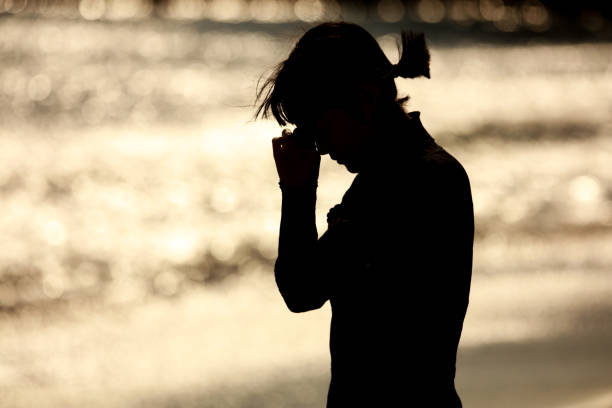 A woman who sheds tears on the beach A woman who sheds tears on the beach divorce beach stock pictures, royalty-free photos & images