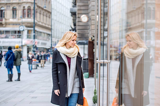woman window shopping in centre of the city. winter - etalages kijken stockfoto's en -beelden