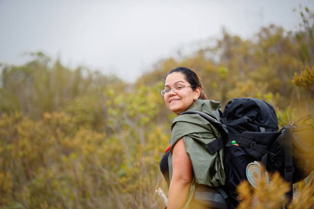 Woman with a backpack climbs a mountain hiking equipment. stock photo