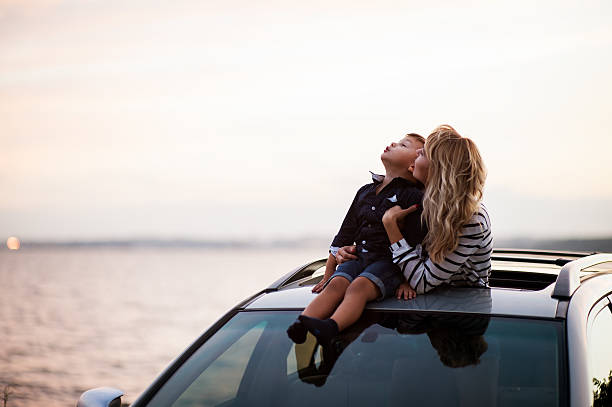 woman with a child  in the car Beautiful woman with a child of four years in the car are going to have a trip car lifestyle stock pictures, royalty-free photos & images