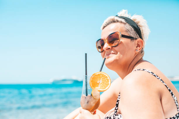 Woman with a cocktail on the beach Woman with a cocktail on the beach lepro stock pictures, royalty-free photos & images