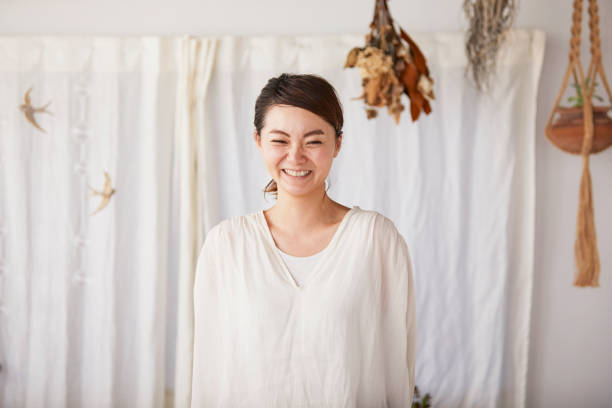 A woman with a smile. A woman with a smile in the room. shy japanese woman stock pictures, royalty-free photos & images