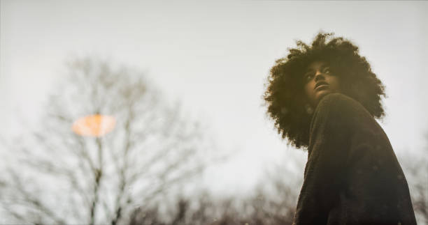 Woman with afro hairstyle reflected in a pond Young woman with afro hairstyle exploring the woods loneliness photos stock pictures, royalty-free photos & images