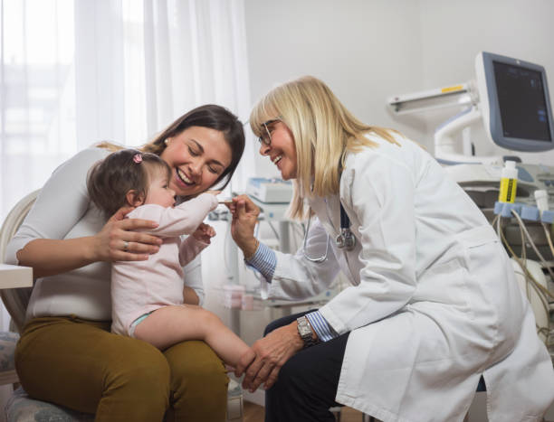 Woman with baby girl in doctor's office stock photo