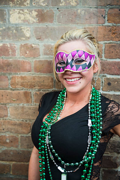 Woman with beads at Mardi Gras in New Orleans A woman enjoying Mardi Gras 2013, wearing mask and beads on Bourbon Street in New Orleans, Louisiana mardi gras women stock pictures, royalty-free photos & images