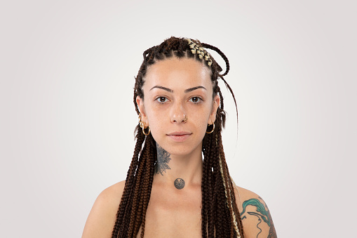 Stylish woman with braided hair and tattoo over white background