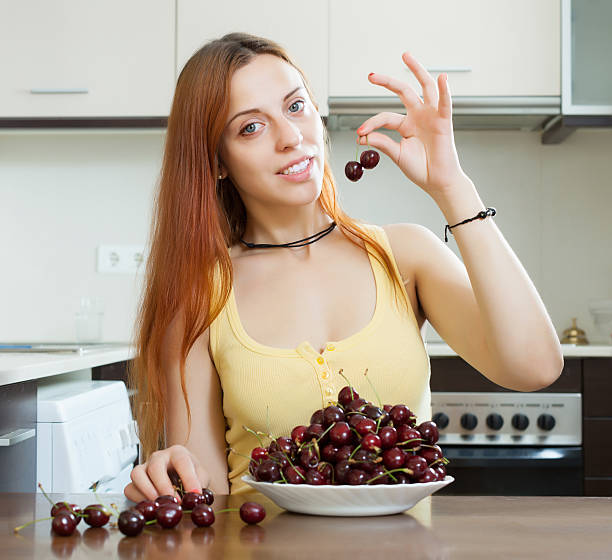 young woman with cherries in home