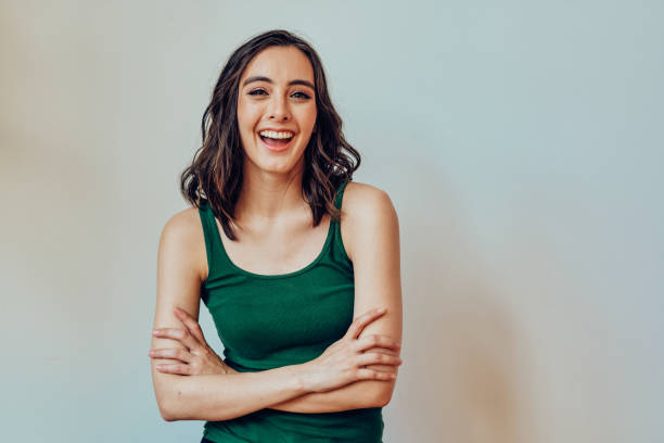 Woman with closed arms laughing looking at camera stock photo