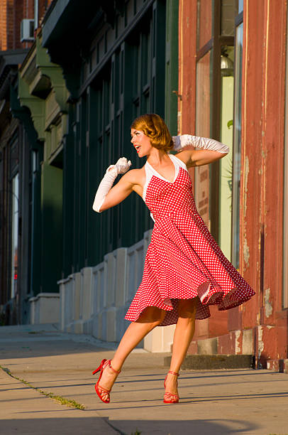 Woman with dress dancing happily in the street stock photo
