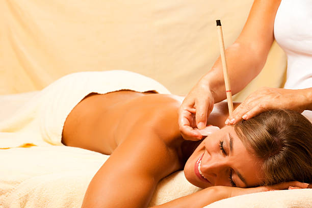 Woman with ear candles and gem massage stock photo