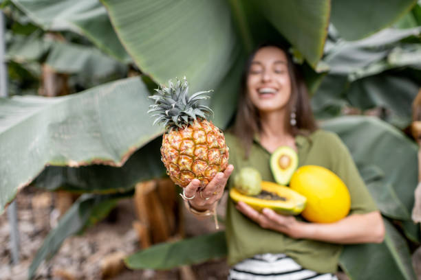 frau mit exotischen speisen im freien - pineapple plantation stock-fotos und bilder