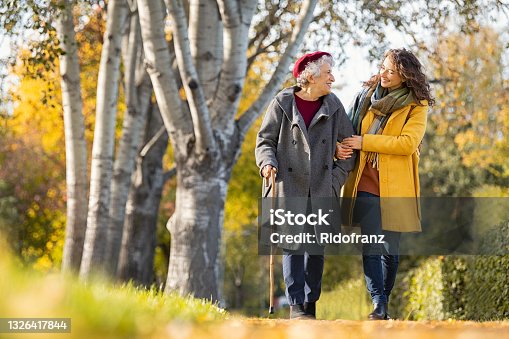 istock Woman with grandmother walking in park in autumn 1326417844
