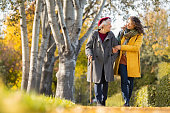 istock Woman with grandmother walking in park in autumn 1326417844