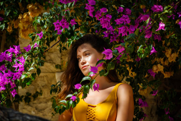 Woman with great purple flowers growing up along the walls, Monaco stock photo