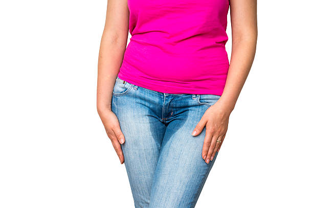 Woman with hands holding her crotch - incontinence concept stock photo