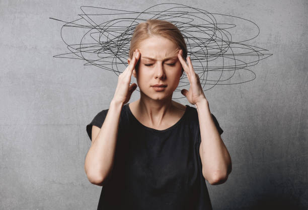 Woman with headache on grey background stock photo