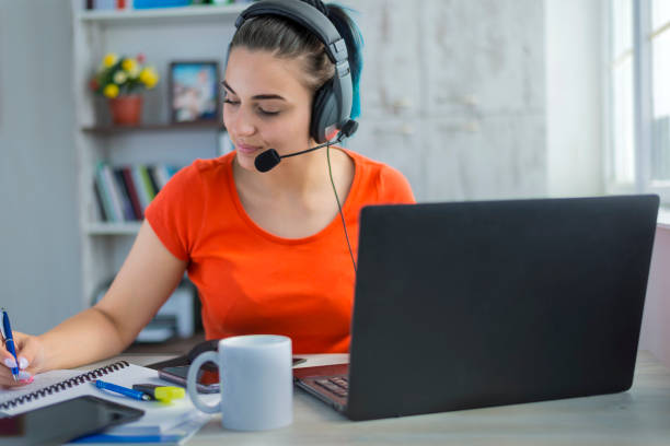 Woman with headphones working from home. stock photo