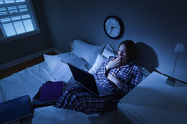 woman with insomnia, college student in bed working on computer - student night study stressed stockfoto's en -beelden