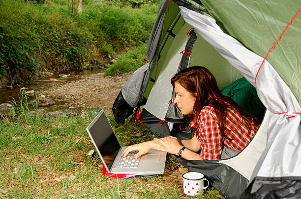 Woman with Laptop - camping serie stock photo
