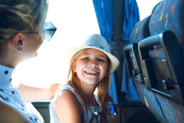 Woman with little daughter sitting in bus stock photo