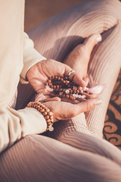 woman with mala beads meditating stock photo