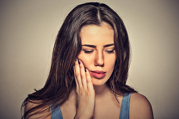 woman with sensitive toothache about to cry from pain - abces stockfoto's en -beelden