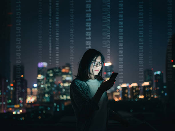 Woman with Smartphone Standing on Skyscraper Roof stock photo