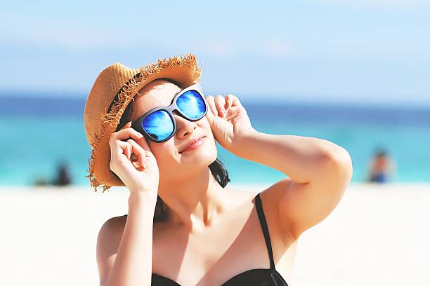 Woman with sunglasses in bikini, Sunglasses reflects the sun. stock photo